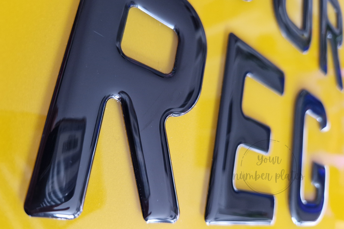 Close up view of a 3d gel number plate in yellow with black 3d gell letters 